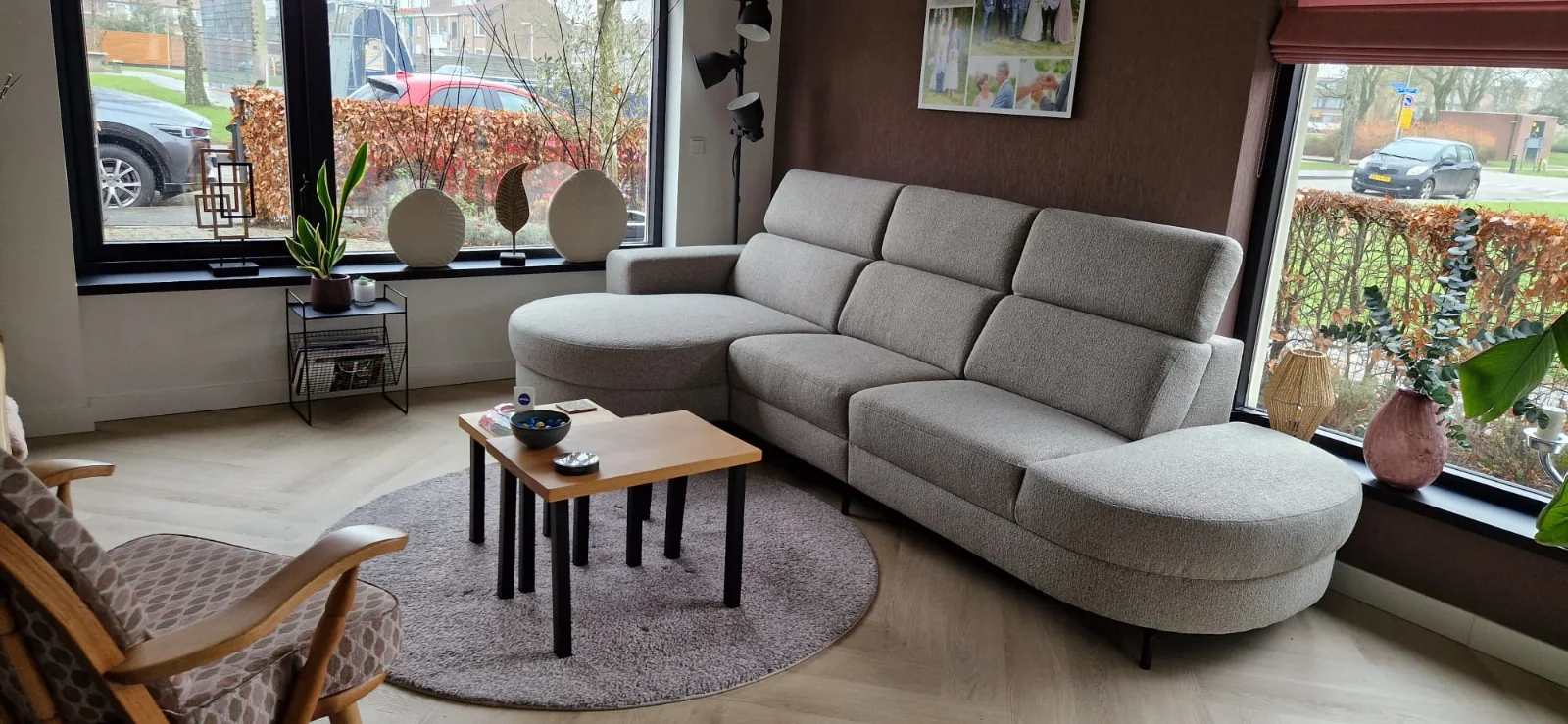 Binnenkijker met lichtgrijze hoekbank met ronde vormen in een sfeervolle woonkamer